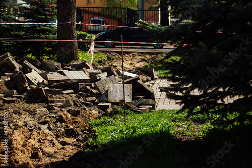 a warning ribbon prohibits passage. cordon tape around the dangerous place. repair work at the site of the asphalt failure after the disaster. cordon around the quarantine zone
