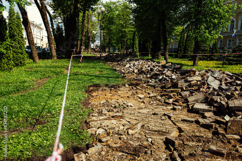a warning ribbon prohibits passage. cordon tape around the dangerous place. repair work at the site of the asphalt failure after the disaster. cordon around the quarantine zone