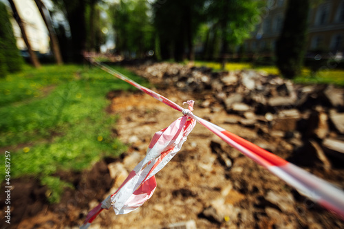 a warning ribbon prohibits passage. cordon tape around the dangerous place. repair work at the site of the asphalt failure after the disaster. cordon around the quarantine zone