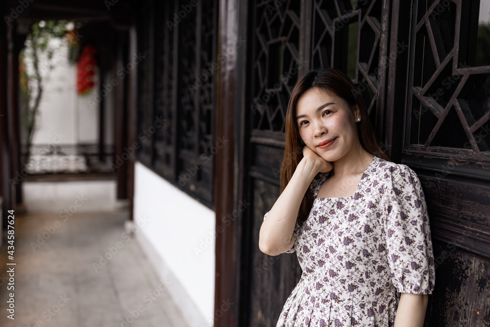 Fototapeta premium Portrait of young asian woman wearing stylish summer dress and walking outdoor in old city. Happy stylish woman with smiley face enjoys life