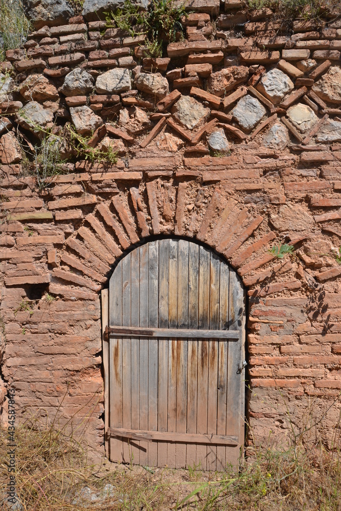 Ancient stone wall with wooden door at Delphi Greece Ancient stone wall with wooden door at Delphi Greece