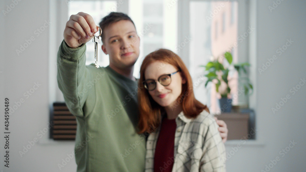 The guy holds a bunch of keys in front of the camera and hugs his girlfriend The guy holds a bunch of keys in front of the camera and hugs his girlfriend