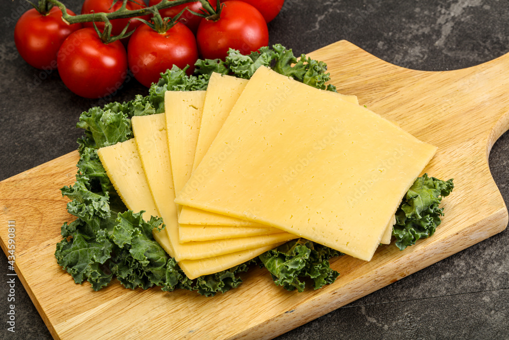 Sliced Gauda cheese over board Sliced Gauda cheese over board