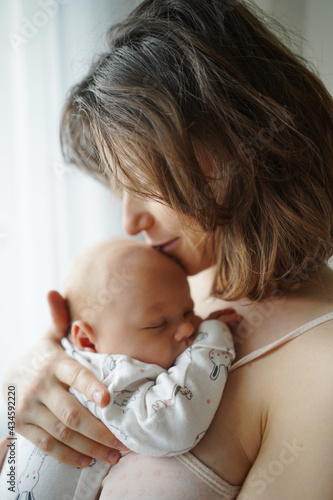 Obraz na płótnie Side view of loving mother gently embracing and kissing adorable sleeping baby at home w salonie