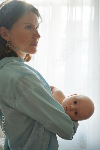 Obraz na płótnie Side view of loving mother standing with adorable infant in room at home w salonie