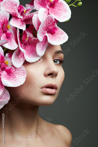 Fototapeta Naklejka Na Ścianę i Meble -  Woman and Flowers. Beauty Portrait of Girl with Orchid flower