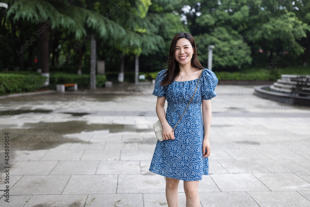 Portrait of young asian woman wearing stylish summer dress and walking outdoor in city. Happy stylish woman with smiley face enjoys life