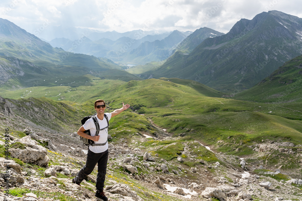 Naklejka premium Young hiker walking with the wonderful panorama of the swiss alps in the background