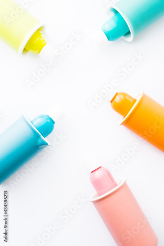 Colored bowl and jar, pantone, colored items diplayed on a white background, egg carrier, and different color paint on plastic container, top view, flatlay, wallpaper type advertisement style.
