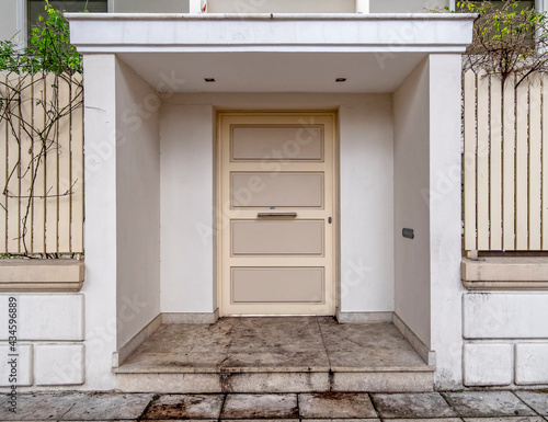 contemporary house front entrance white door by the sidewalk