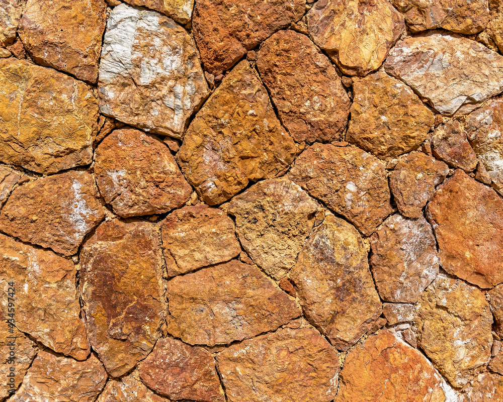 Obraz premium rough irregular cut brown stone wall, seamless pattern textured background
