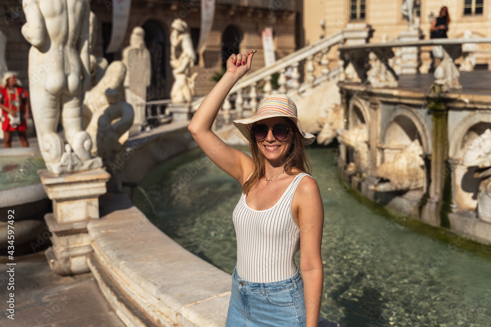 young woman throwing a coin in an Italian fountain in Sicily