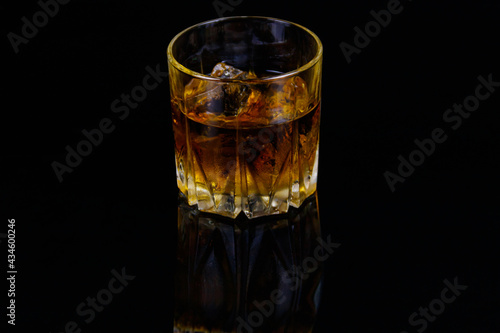 Glass of whiskey with ice on a black background