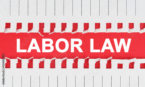 Between two sheets of notebook on a red background the inscription - LABOR LAW photo