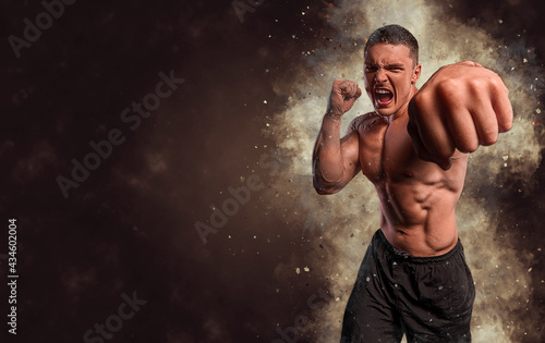 Energy and power boxing concept. Sports advertising. fighting muscular man in smoke on dark background. Athlete muscular brutal bodybuilder emotional posing