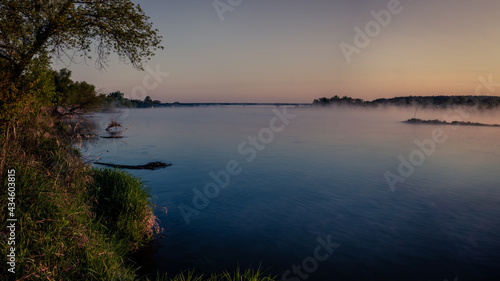 Mglisty wschód słońca nad rzeką Wisłą z mostem w tle i parującą wodą w Annopolu w województwie Lubelskim