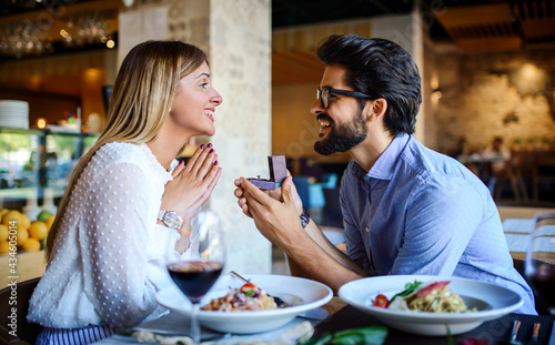 Young man surprised his girlfriend with engagement ring in the restaurant. Lifestyle, love, relationships, food concept