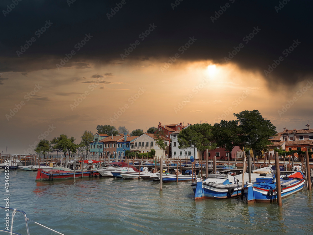 a small pier in venice with boats in summer