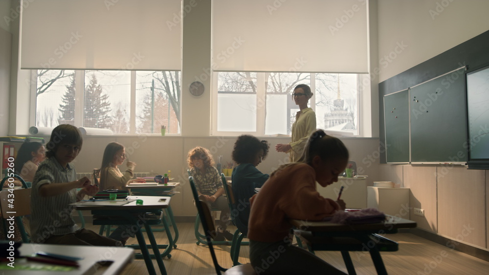 Students learning in classroom. Smart pupils writing in notebooks during lesson Students learning in classroom. Smart pupils writing in notebooks during lesson
