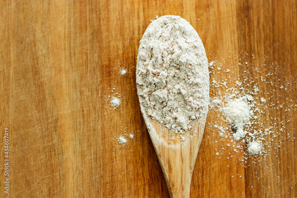 wooden spoon on wood cutting board with flour in kitchen wooden spoon on wood cutting board with flour in kitchen