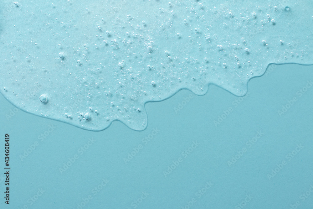 Background from cosmetic gel with bubbles,dripping down.Pastel blue color,copy space for text or design.Top view,antibacterial liquid surface.Good as background or mockup.