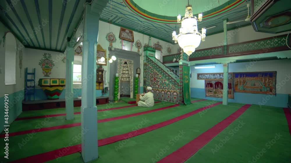 Muslim mosque teacher is reading the quran in in small historic wooden masjid.Mosque interior mystical praying god religion mysterious religious islamism islam moslem place of worship prayer temple 4K Muslim mosque teacher is reading the quran in in small historic wooden masjid.Mosque interior mystical praying god religion mysterious religious islamism islam moslem place of worship prayer temple 4K