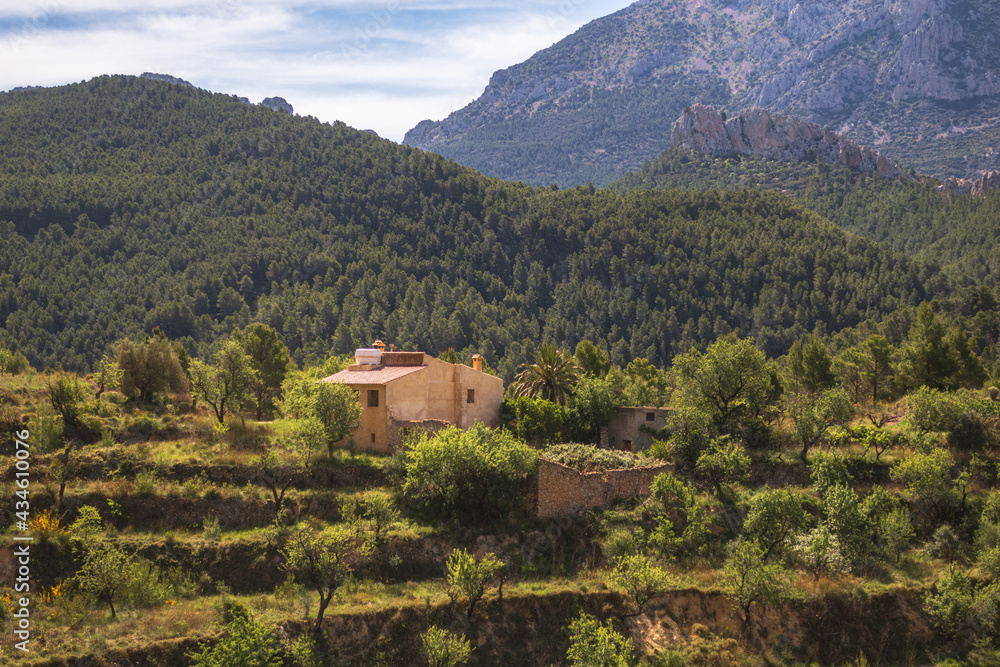 Nature landscape, with a Mediterranean-style rural house surrounded by almond groves, in the interior of Alicante (Spain)