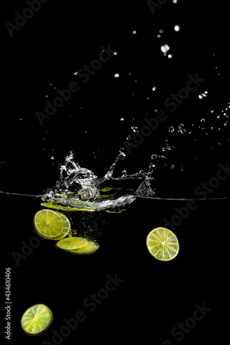 bright juicy fruits with splashes fly into the aquarium on a black background