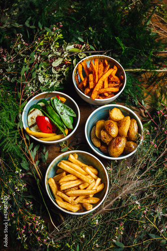 Canvas Print A variety of dishes on a wooden table decorated with plants, different potatoes and vegetables