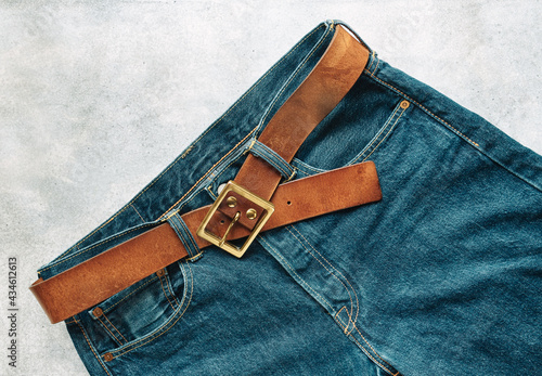 Blue mens denim pants, jeans, with a leather belt, fashion clothing concept. View from above with copy space