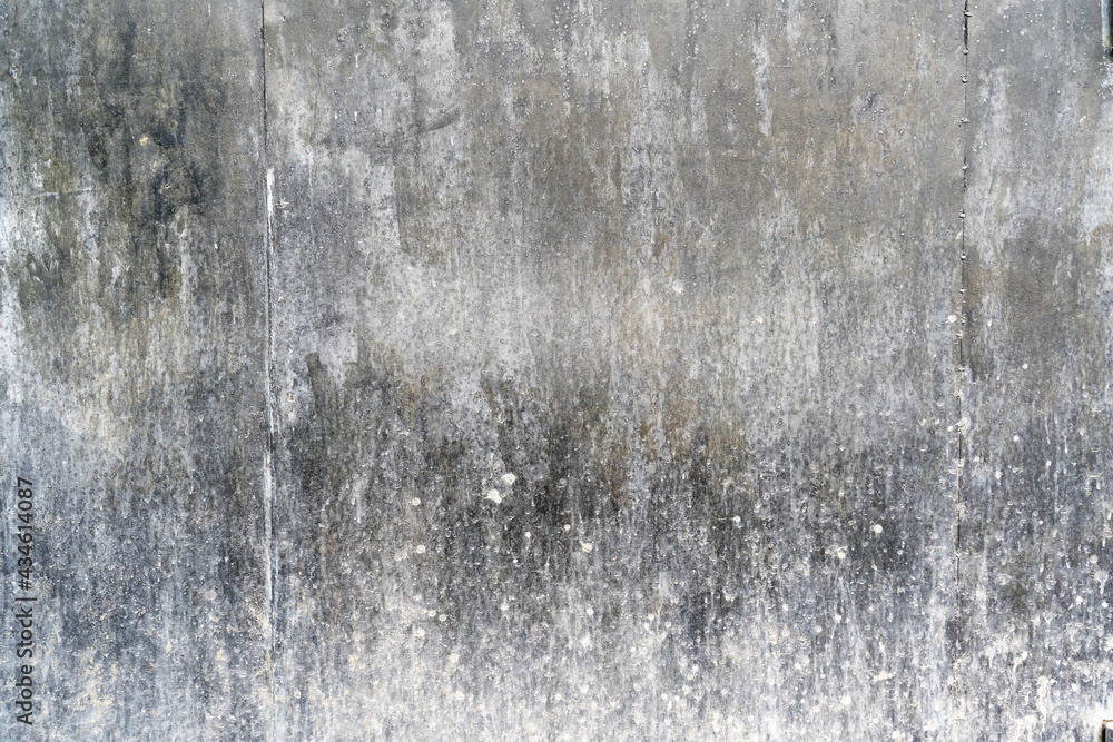 Obraz premium Fragment of a black metal wall. There are two joints between the steel sheets. The lower part is covered with mud. Background. Texture.