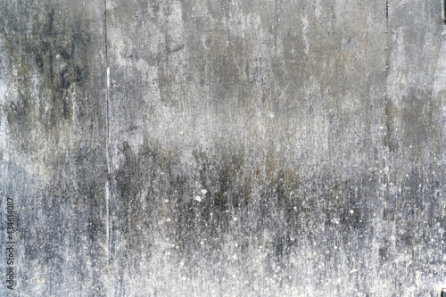 Fragment of a black metal wall. There are two joints between the steel sheets. The lower part is covered with mud. Background. Texture.