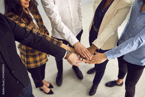 Teamwork, teambuilding, team support and trust, company spirit. Multiethnic diverse business people group friends community hands together stacking in circle midsection studio shot
