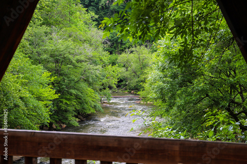 a stunning shot of the rushing river water of Big Creek river with lush green trees and large rocks on the banks and in the middle of the river at Vickery Creek in Roswell Georgia photo