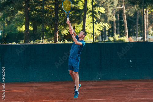 A professional tennis player is serving ball on a clay tennis court © qunica.com