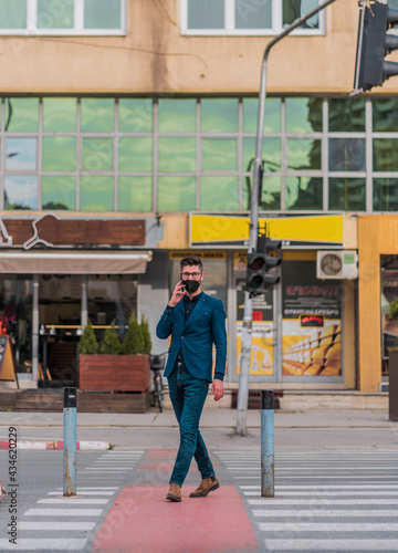 Young businessman in blue suit walking through downtown