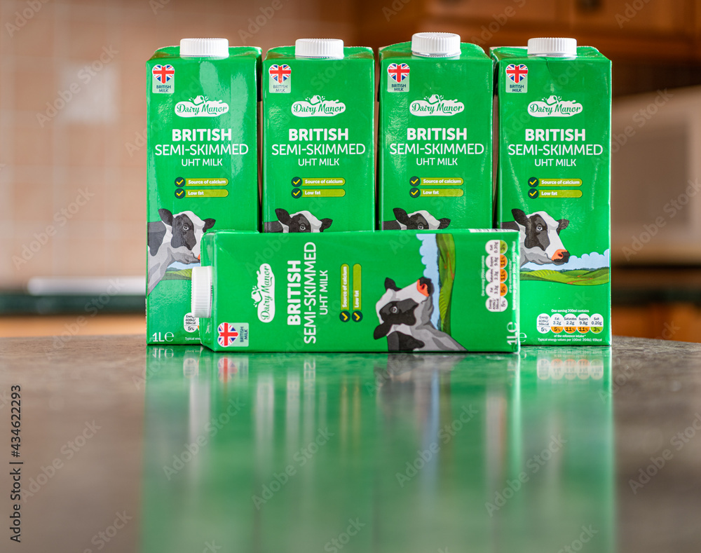 Dairy Manor SemiSkimmed Milk Tetra Pack with a blurred kitchen in the background Stock Photo