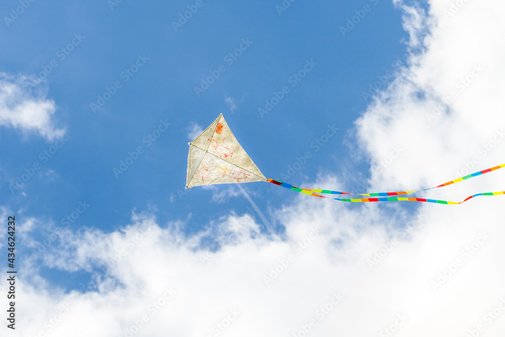 Self-painted kite flies against a blue sky. Creatively painted kite. Kite flying. Selbst bemalter Drachen fliegt vor blauem Himmel. Kreativ bemalter Drachen. Drachen fliegen. 