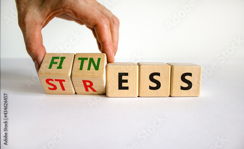 Fitness vs stress symbol. Doctor turns cubes and changes the word 'stress' to 'fitness'. Beautiful white table, white background. Medical, psychological, fitness vs stress concept. Copy space. photo