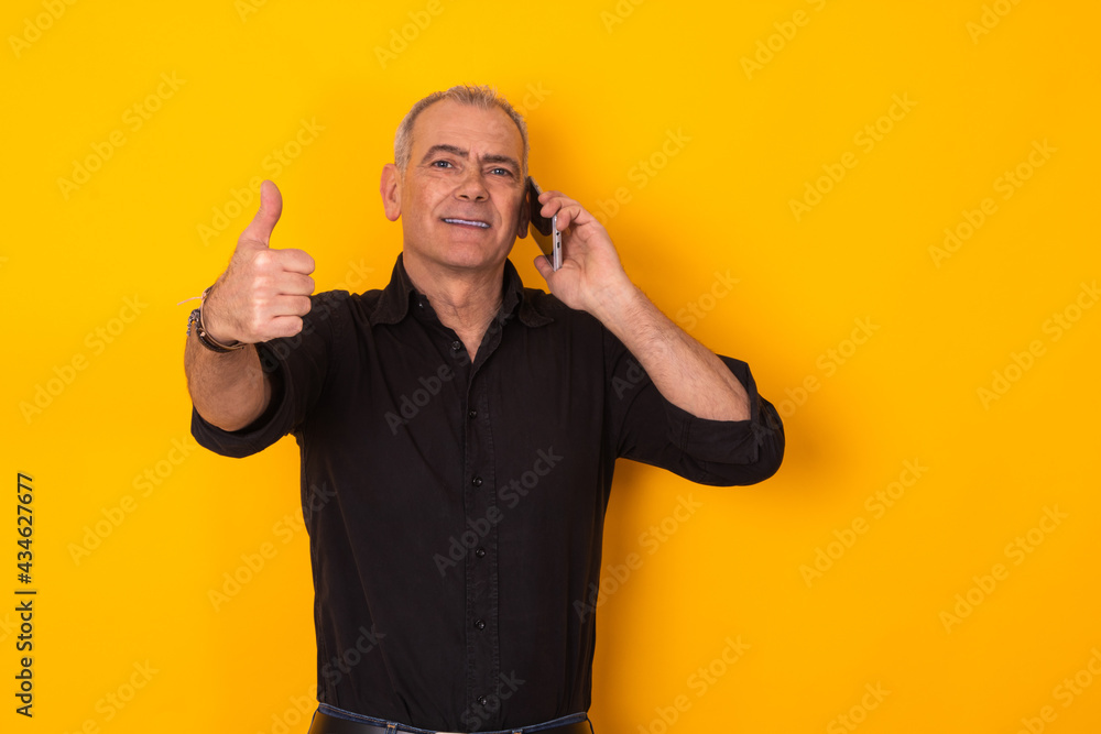 businessman talking on the phone isolated on yellow color background with okay sign businessman talking on the phone isolated on yellow color background with okay sign