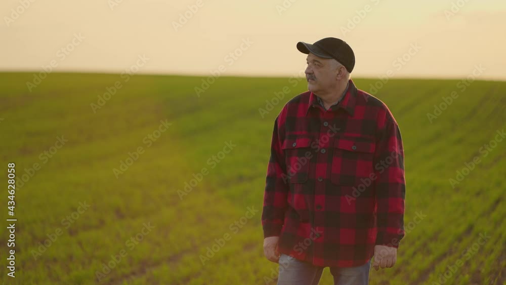 Portrait of a tractor farmer walking through a field at sunset after a slow-motion shoot Portrait of a tractor farmer walking through a field at sunset after a slow-motion shoot