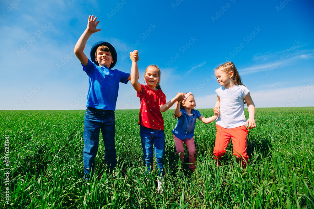 Happy Children on a green field with their hands up. Happy Children on a green field with their hands up.