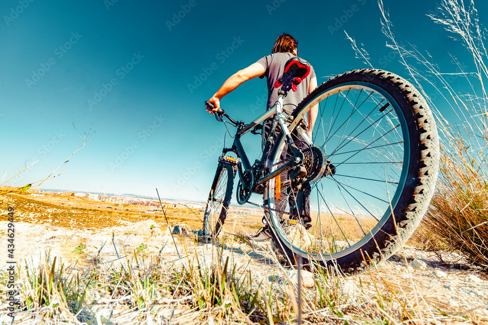 Deportes de bicicleta y concepto de aventurero.. Deportes extremos con bicicleta de montaña y puesta de sol en paisaje natural.Entretenimiento y ocio deportivo saludable - obrazy, fototapety, plakaty 