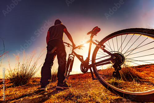 Deportes de bicicleta y concepto de aventurero.. Deportes extremos con bicicleta de montaña y puesta de sol en paisaje natural.Entretenimiento y ocio deportivo saludable