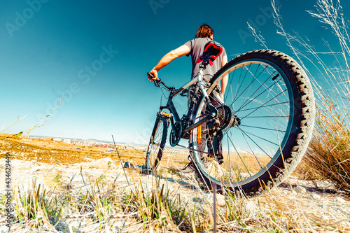 Deportes de bicicleta y concepto de aventurero.. Deportes extremos con bicicleta de montaña y puesta de sol en paisaje natural.Entretenimiento y ocio deportivo saludable © C.Castilla