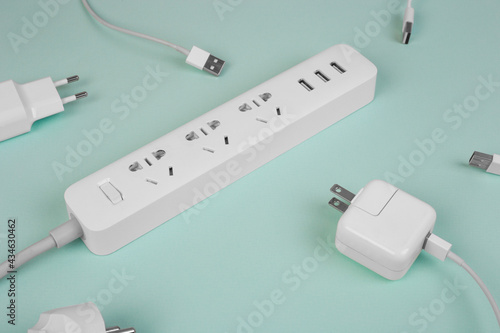 Stylish white electric extender with sockets on tiffany background . Electrical power white strip or extension block. Many wires and sockets. High-tech smart strip. Close up.