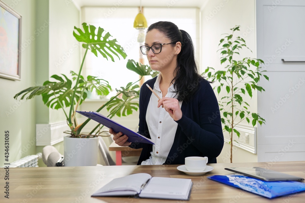 Business woman looking at camera talking, holding papers documents in hands Business woman looking at camera talking, holding papers documents in hands