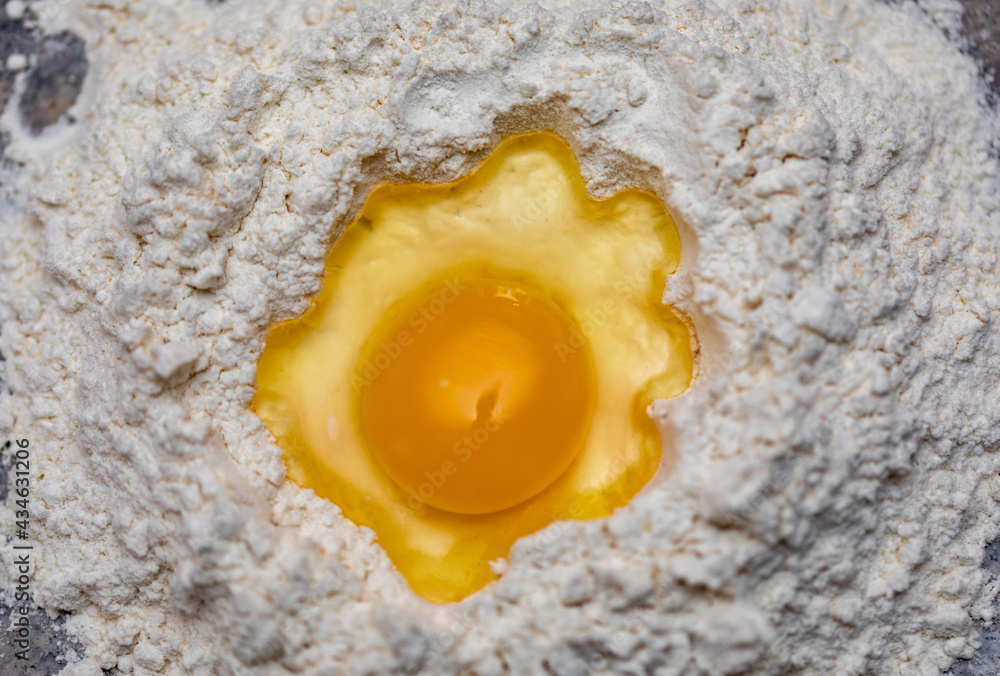 raw egg in a hole of flour