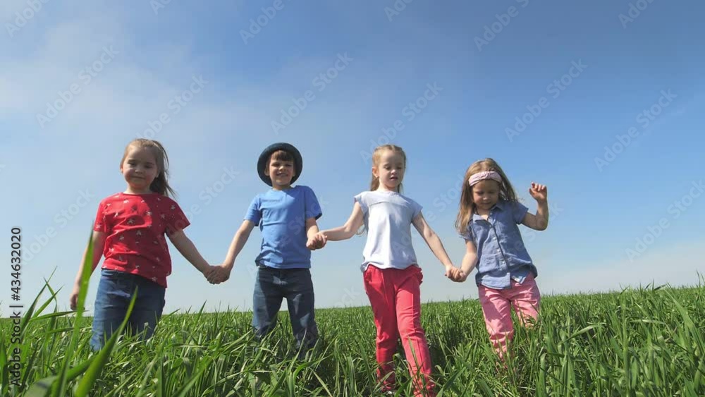 Children stand in a field holding hands, holding them high in the air and laughing. Children stand in a field in the tall grass, laughing and looking at the camera. Slow-motion Children stand in a field holding hands, holding them high in the air and laughing. Children stand in a field in the tall grass, laughing and looking at the camera. Slow-motion