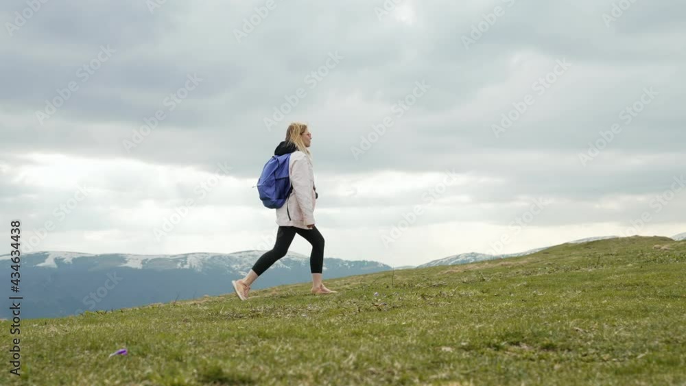 Young traveller woman walking alone on top of high mountain. Lady with backpack. Healthy lifestyle, nature, fresh air, trip concept Young traveller woman walking alone on top of high mountain. Lady with backpack. Healthy lifestyle, nature, fresh air, trip concept